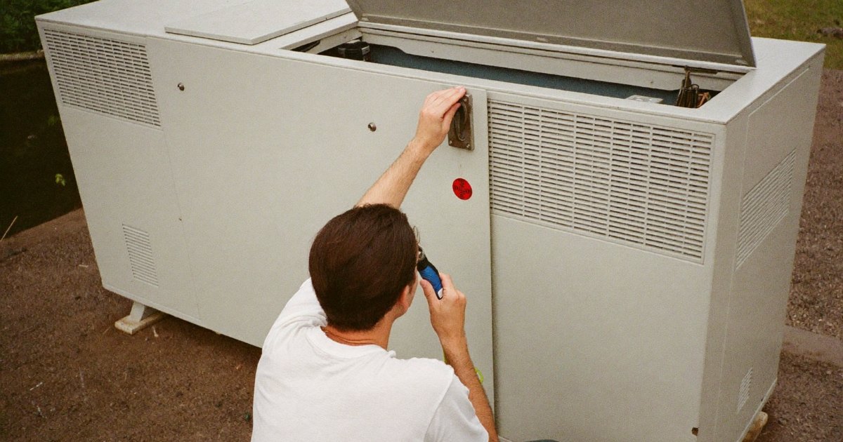 Homeowner checking the battery of a standby generator with a flashlight