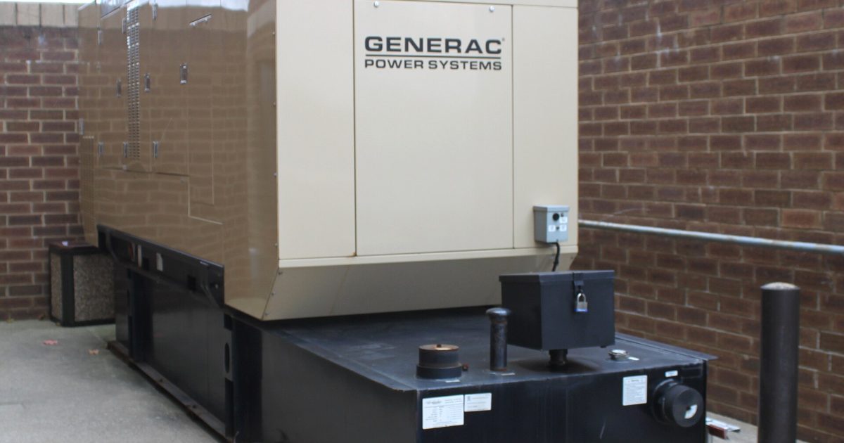 Generac standby generator installed beside a brick building
