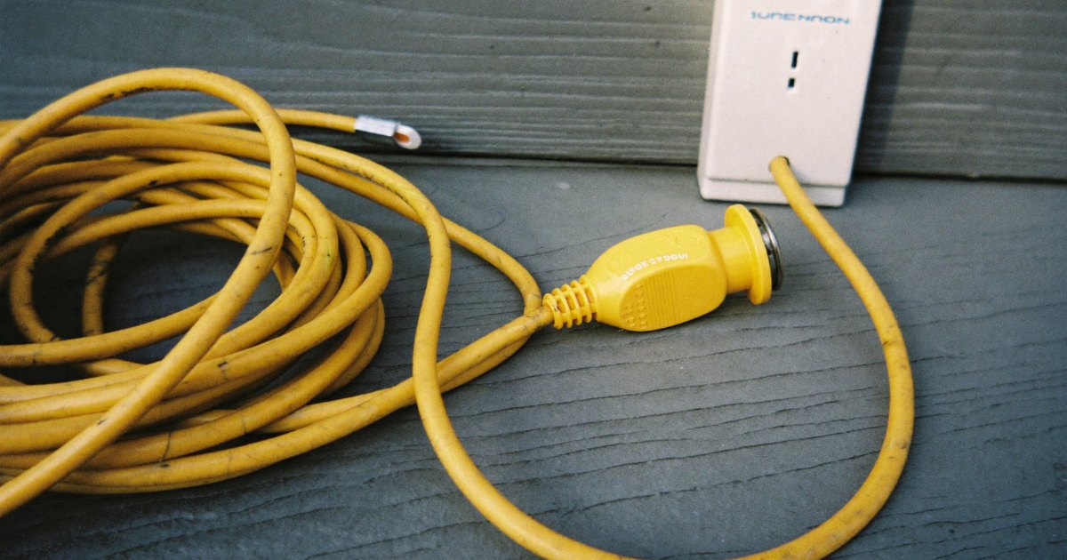 Generator cord with twist-lock plug next to an outdoor power inlet box