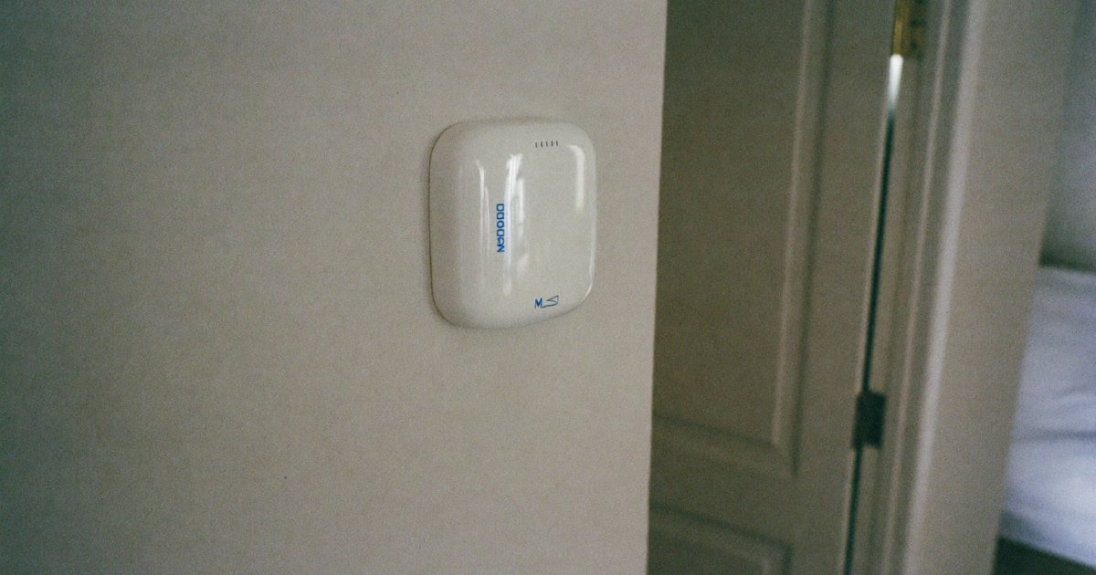 Carbon monoxide alarm on a hallway wall near a bedroom