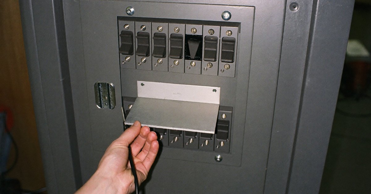 Open breaker panel with a sliding interlock plate