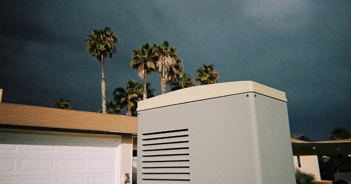 Coastal house with a standby generator under approaching storm clouds