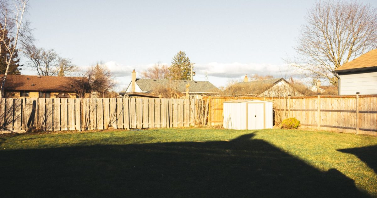Residential backyard with a wooden fence between neighbors