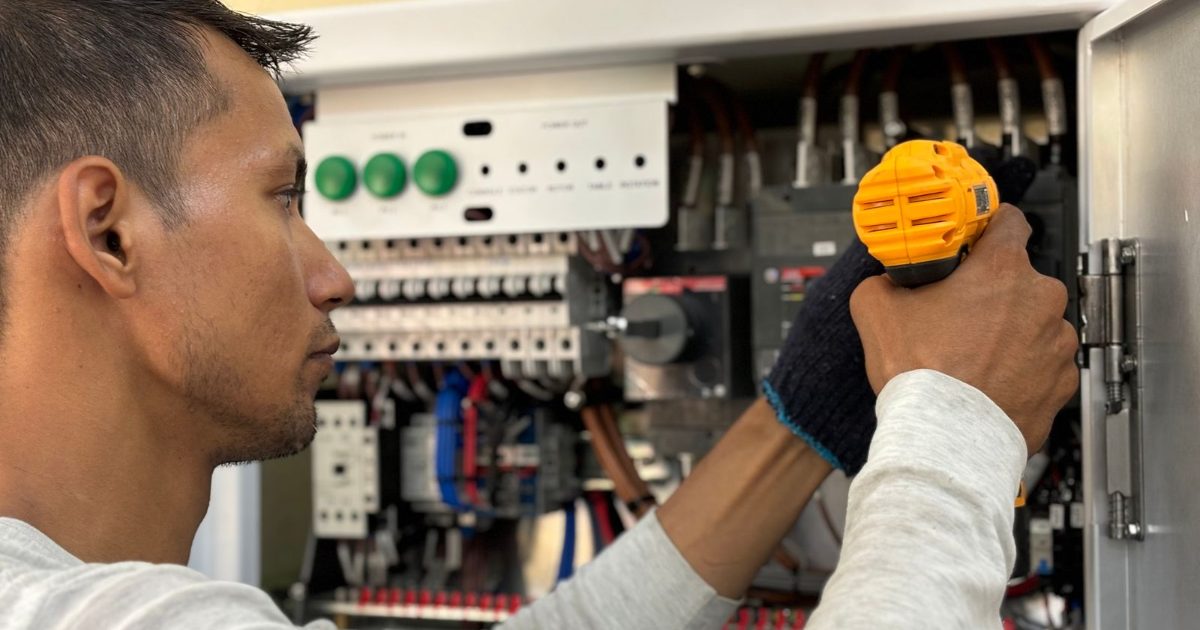 Technician working on electrical equipment during a service visit