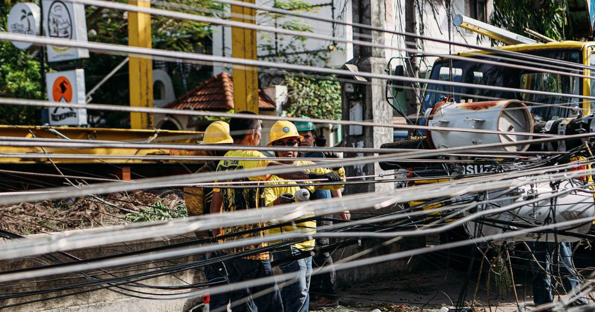 Utility workers repairing downed power lines